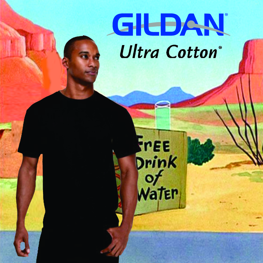 Gildan_2000_2 Man wearing a plain black t-shirt standing in front of a cartoon desert background with red rock formations and a sign that reads Free Drink of Water, with the Gildan Ultra Cotton logo above.