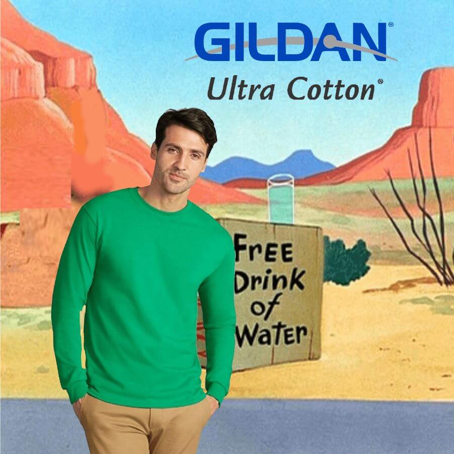 Man wearing a green long-sleeve Gildan Ultra Cotton t-shirt standing in front of a desert landscape backdrop with a sign reading 'Free Drink of Water'