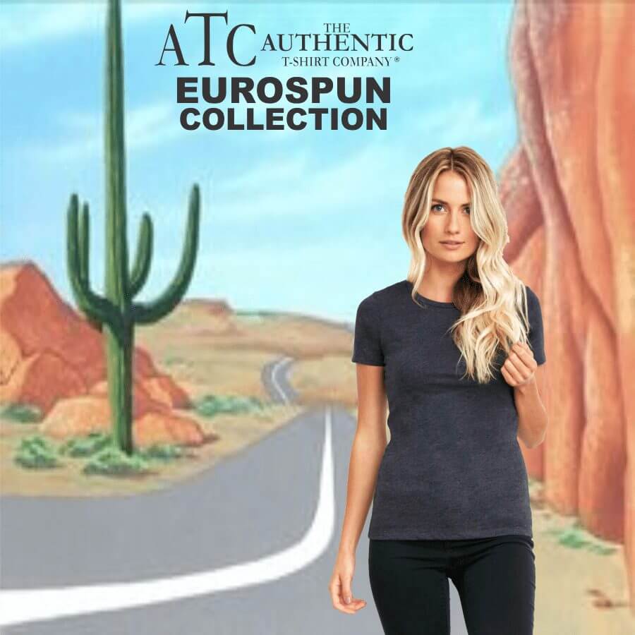 8000L Woman wearing a fitted dark grey short-sleeve t-shirt and black pants standing in front of a desert road background with cacti and red rock formations