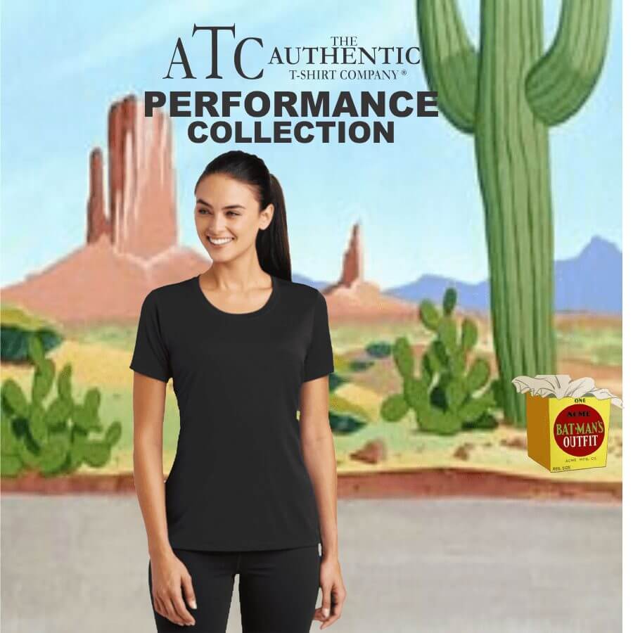 Smiling woman wearing a black short-sleeve performance T-shirt and black leggings, standing outdoors with desert scenery background featuring cacti and rock formations, ATC Authentic T-Shirt Company Performance Collection branding above.