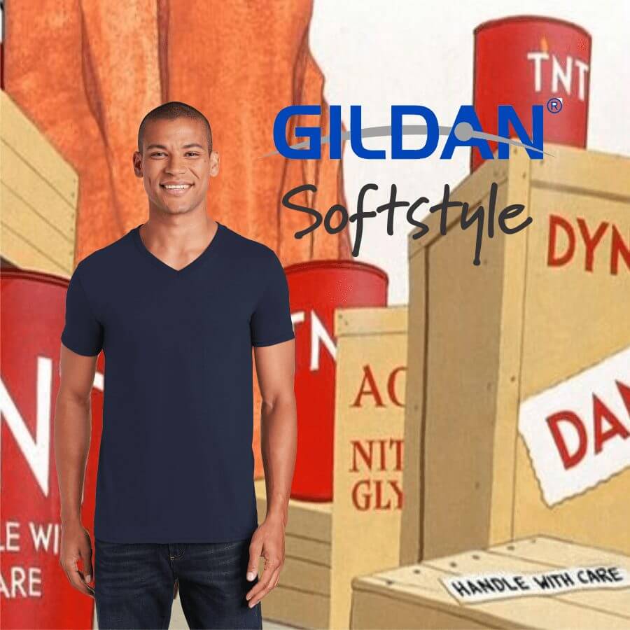 G640V Smiling man wearing a navy blue V-neck Gildan Softstyle t-shirt standing against a backdrop of cartoon-style explosive crates and barrels