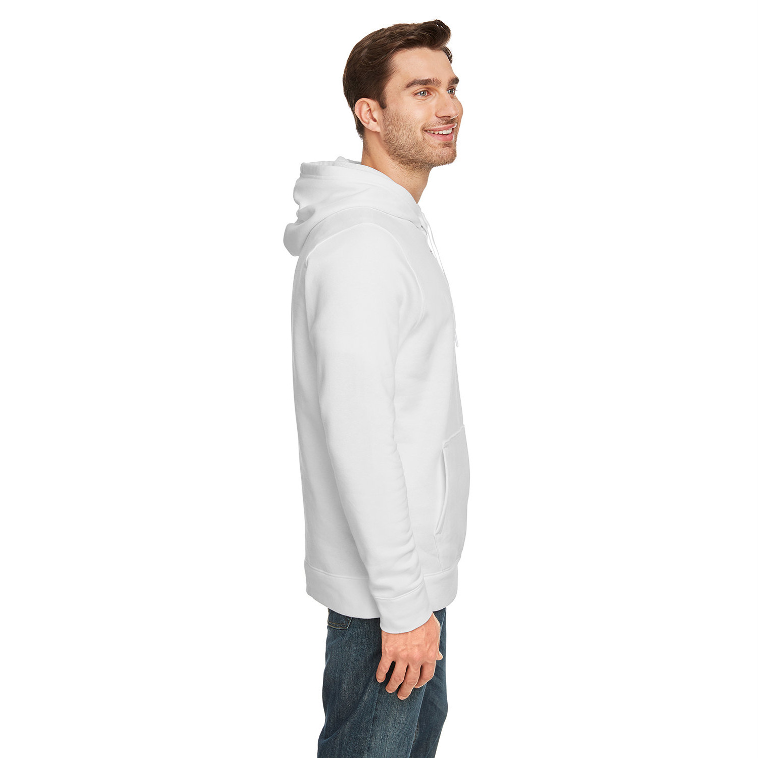 Smiling man standing in profile wearing a plain white hoodie and blue jeans against a white background