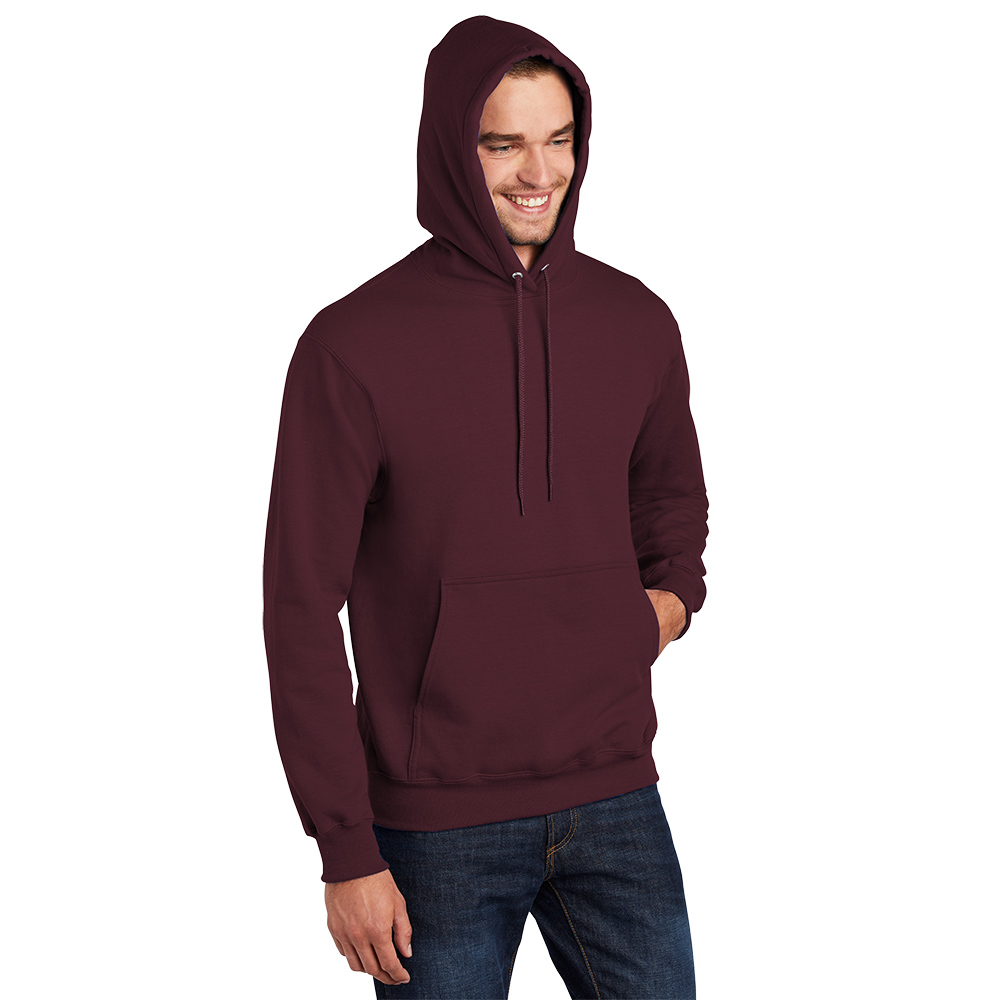 Man wearing a maroon hooded sweatshirt with hands partially in front pocket, smiling and looking down, paired with blue jeans on a white background.