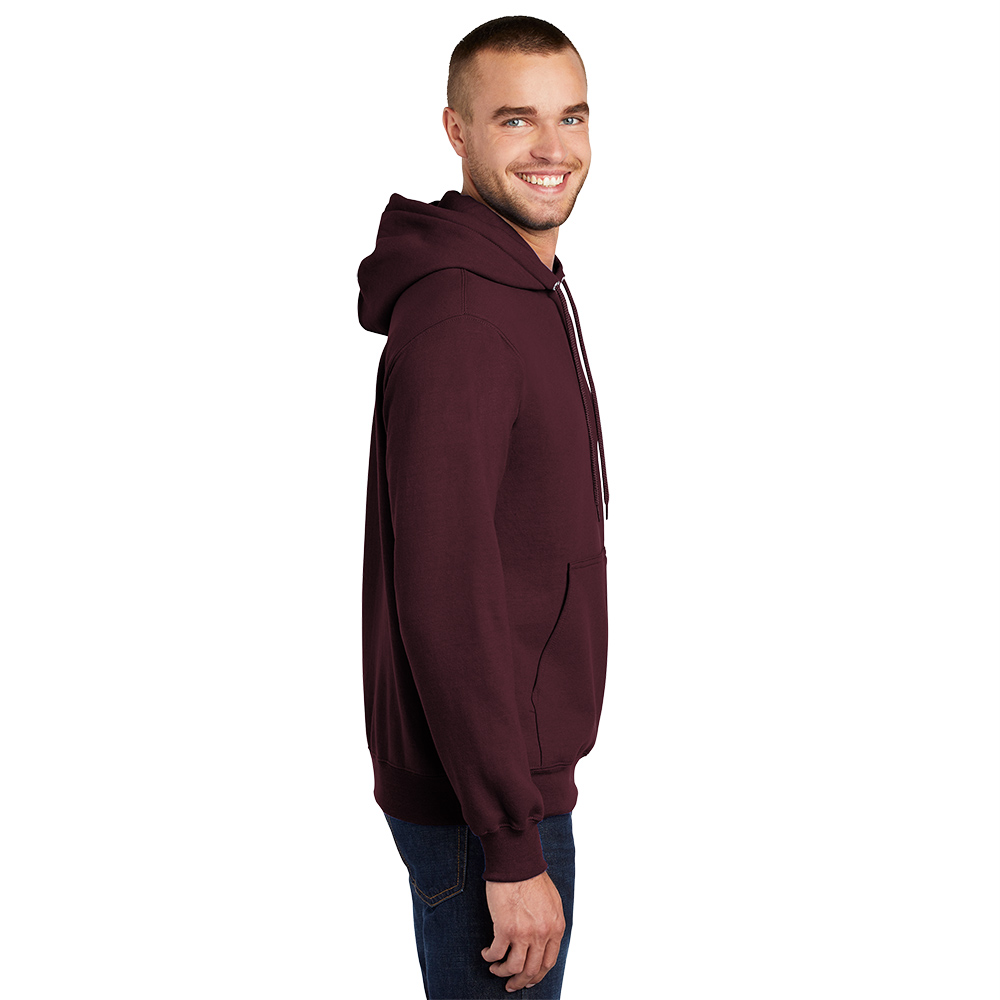 Side view of a smiling man wearing a maroon hoodie and blue jeans against a white background.