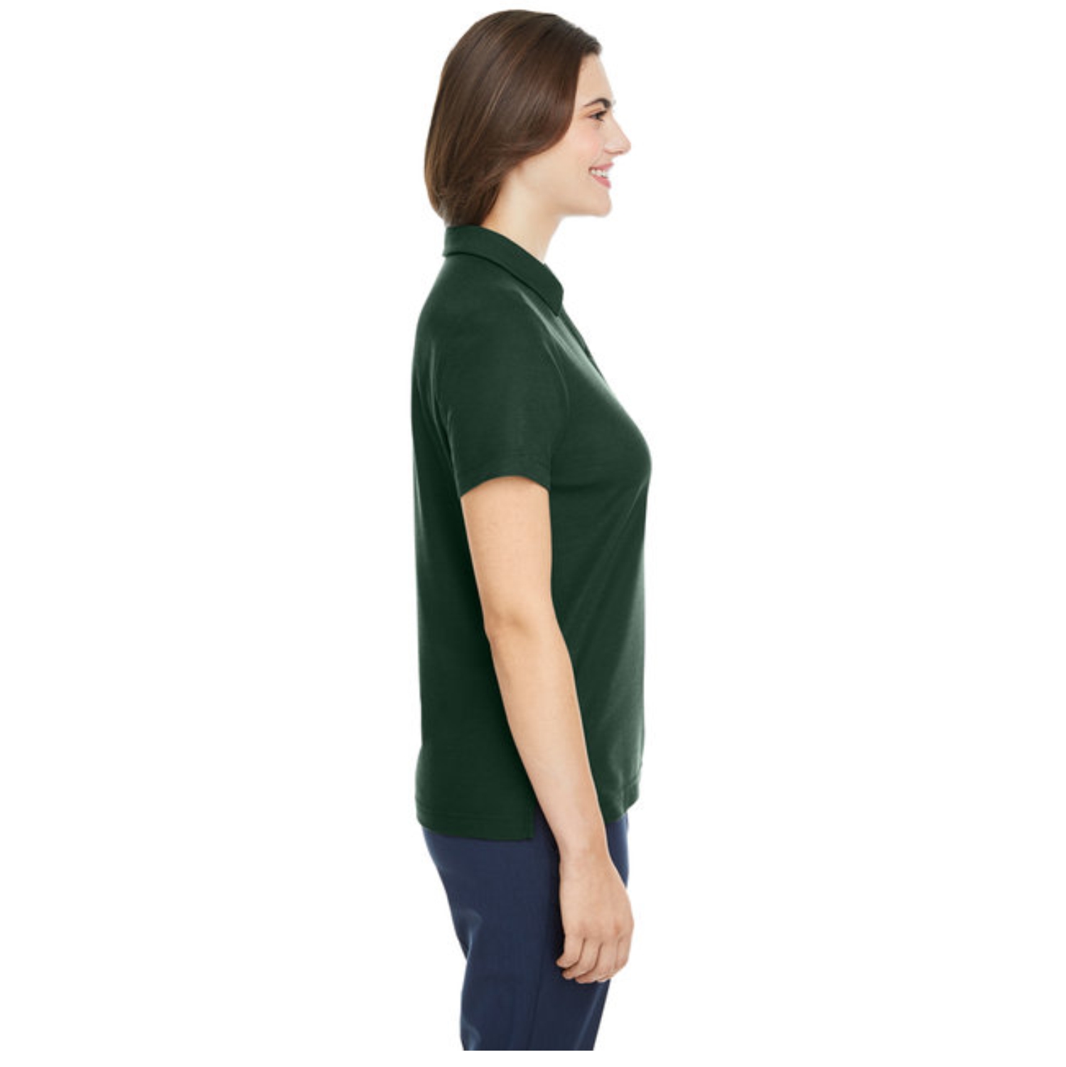 Profile view of a smiling woman with brown hair wearing a dark green collared short-sleeve shirt and dark blue pants against a white background.