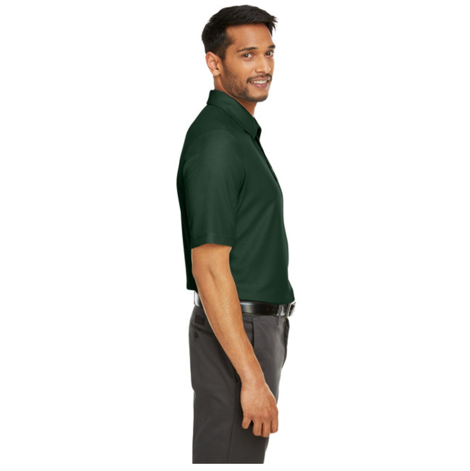 Side view of a smiling man wearing a dark green short-sleeve polo shirt tucked into gray pants with a black belt against a white background