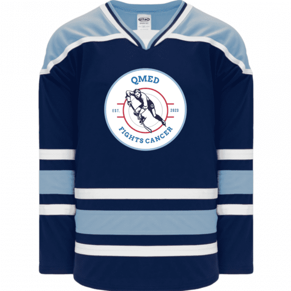 Athletic Knit H550B hockey jersey navy blue hockey jersey featuring a circular logo that reads "QMED Fights Cancer" with an illustration of a hockey player, established in 2023. The jersey has carolina blue and white stripes on the sleeves and bottom hem, promoting cancer awareness through sports.