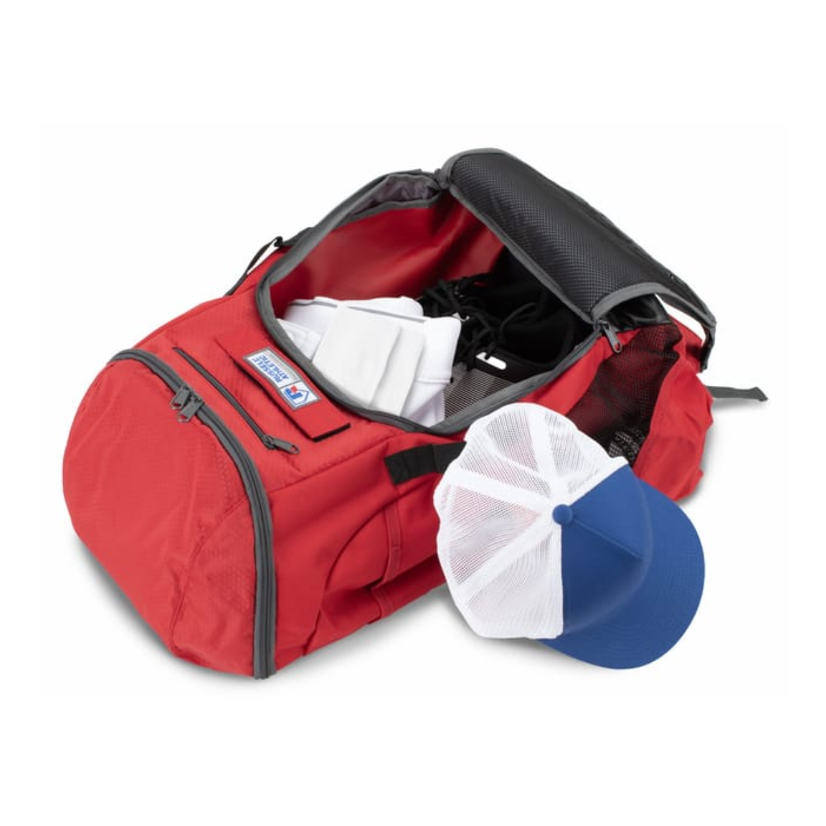 colts_diamond_backpack__pic_1 Red sports duffel bag with an open top, revealing packed athletic gear, including white clothing and black shoes, alongside a blue and white baseball cap. Ideal for carrying sports equipment and accessories.