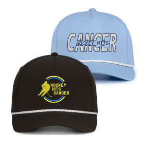 Two stylish caps featuring the "Hockey Hits Cancer" theme. The top cap is light blue with bold lettering, while the bottom cap is black with a colorful hockey player graphic. Perfect for supporting cancer awareness in the hockey community.