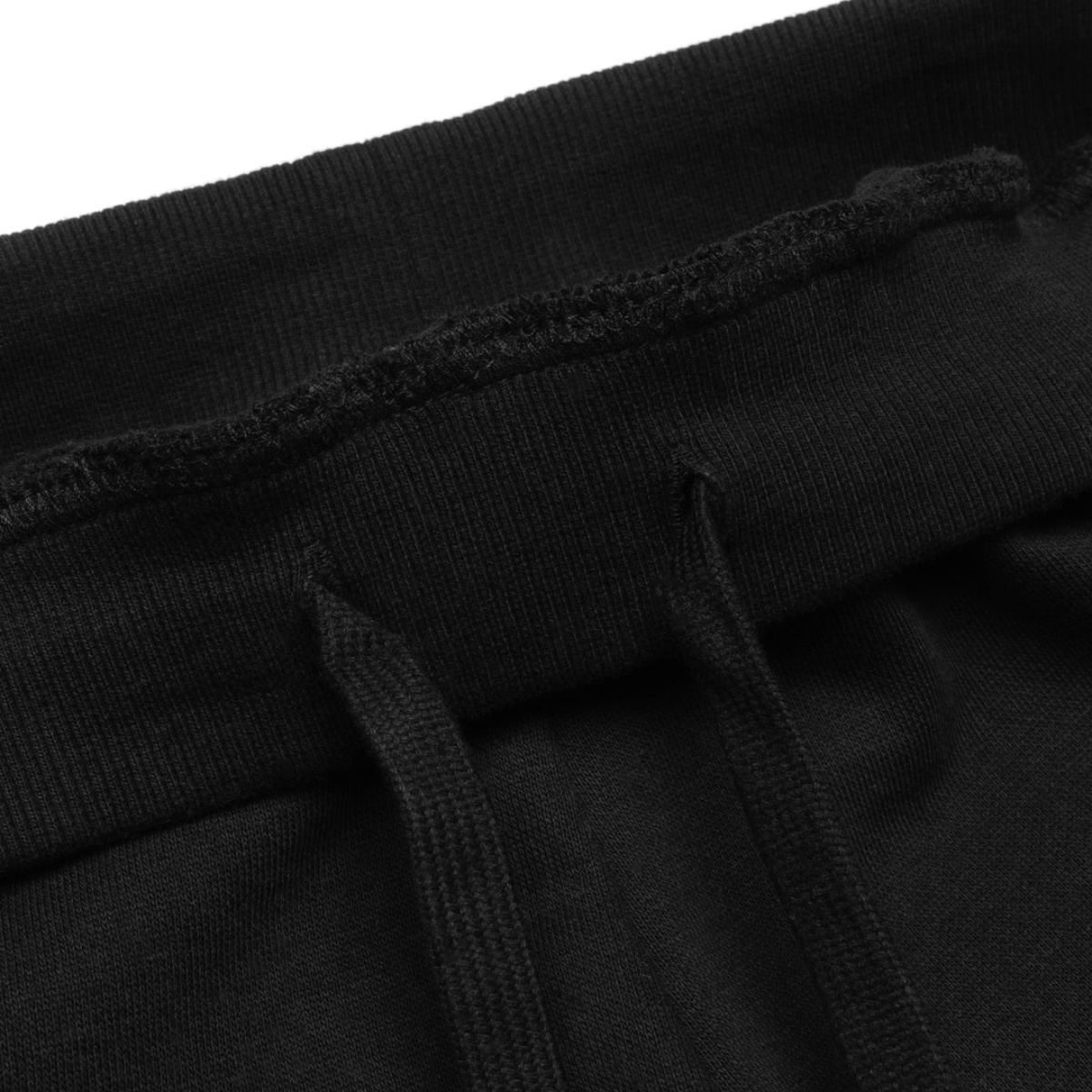 Close-up of the waistband and drawstrings of black sweatpants, showcasing the fabric texture and stitching details for enhanced comfort and style.
